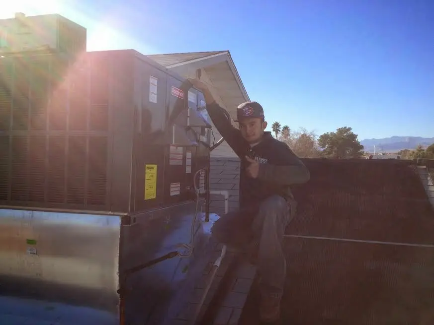 HVAC technician performing Air Duct Repair on a rooftop unit in Rancho San Diego